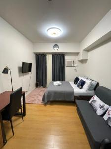 マニラにある8 Adriaticoのベッドとソファ付きのホテルルーム