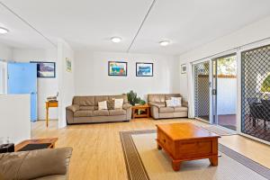 a living room with two couches and a table at The Islander in Point Lookout