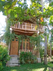 une cabane dans les arbres avec une véranda et un balcon dans l'établissement Coconut Island Yala, à Tissamaharama