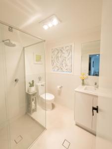 a white bathroom with a shower and a toilet at Treveth in Angaston