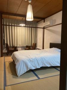a bedroom with a large bed and a dining room at Hotel shirahama in Shirahama