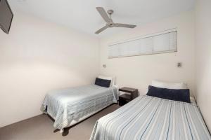 a bedroom with two beds and a ceiling fan at French Quarter Apartment 116, Noosa Heads in Noosa Heads