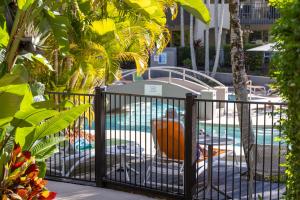 a fence next to a swimming pool with a pool at French Quarter Apartment 116, Noosa Heads in Noosa Heads