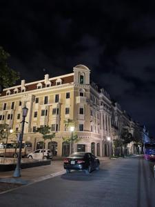 um carro estacionado em frente a um edifício à noite em Sao Việt HTH Hotel em Ha Long