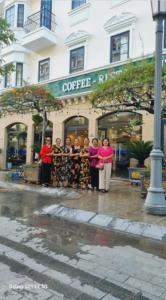um grupo de mulheres em pé em frente a um café em Sao Việt HTH Hotel em Ha Long