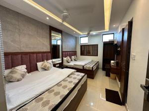 a hotel room with two beds and a mirror at Hotel Seeta Since 1965 in Amritsar