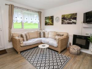 a living room with a couch and a tv at Villa No 50 in Lanteglos