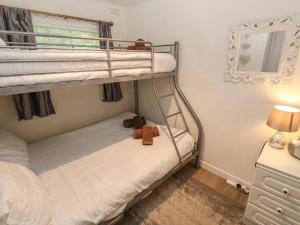 a bedroom with two bunk beds with a teddy bear at Villa No 50 in Lanteglos