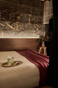 Ce lit se trouve dans une chambre dotée d'un mur en briques. dans l'établissement The Interlude, à Melbourne
