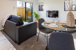 a living room with a dining room table and a couch at Coastal Sands Escape 1 bed 1 bath w/sofa bed in Christchurch