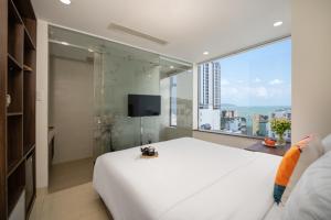 1 dormitorio con 1 cama blanca grande y ventana grande en RAON Hotel - STAY 24H, en Quy Nhon