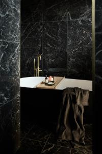 bagno con vasca bianca e lavandino di The Interlude a Melbourne