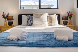a bedroom with a large bed with towels on it at Coastal Sands Escape 1 bed 1 bath w/sofa bed in Christchurch