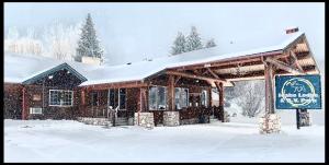 a building with a sign in the snow at The Idaho Lodge & RV Park in Bonners Ferry