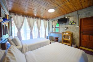1 Schlafzimmer mit 2 Betten und einem Fenster in der Unterkunft เฮินไต รีสอร์ท แม่ลาน้อย in Mēlānoi