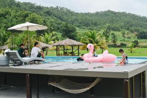einen Pool mit einem rosa Flamingo in einem Pool in der Unterkunft เฮินไต รีสอร์ท แม่ลาน้อย in Mēlānoi