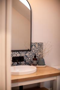een badkamer met een wastafel en een spiegel bij The Pearl Tasmania in White Beach