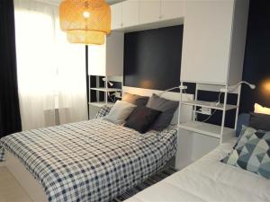 um quarto com uma cama com um cobertor xadrez em Appartement Saint-Jean-de-Monts, 3 pièces, 5 personnes - FR-1-323-280 em Saint-Jean-de-Monts