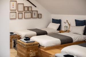 drie bedden in een kamer met wit en blauw bij The Pearl Tasmania in White Beach