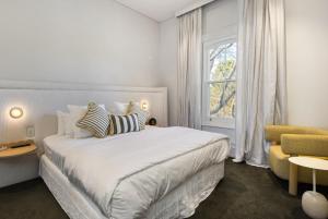 The Stirling Hotel في ستيرلينغ: غرفة نوم بيضاء بها سرير ونافذة