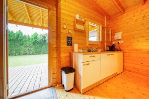 una cocina en una cabaña de madera con fregadero en Le cottage en La Plaine-des-Palmistes