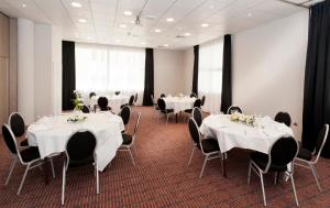 une salle de conférence avec des tables et des chaises blanches dans l'établissement Holiday Inn Toulon City Centre, an IHG Hotel, à Toulon