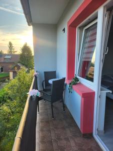 einen Balkon mit einem Tisch und Stühlen auf einem Haus in der Unterkunft Apartament u Irenki in Harklowa