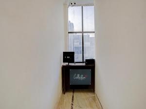 a corner of a room with a television and a window at Collection O The Pinaki Residency Near Dlf Avenue Saket in New Delhi