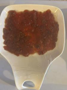 Un plato blanco con un trozo de salsa. en Al Namteh Lodge en ‘Ābil