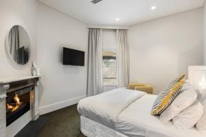 um quarto branco com uma lareira e uma cama em The Stirling Hotel em Stirling