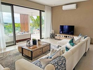 sala de estar con sofá, TV y mesa en Luxury 4 Bed Penthouse, Pool & stunning Sea views en Grand Baie