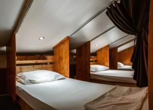 Duas camas num quarto com paredes de madeira em Frendz Hostel Boracay em Boracay