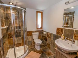 a bathroom with a toilet and a shower and a sink at The Gatehouse in Sutton in Ashfield