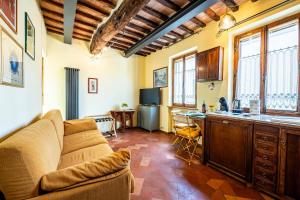 ein Wohnzimmer mit einem Sofa und einer Küche in der Unterkunft The Sunflower in Siena