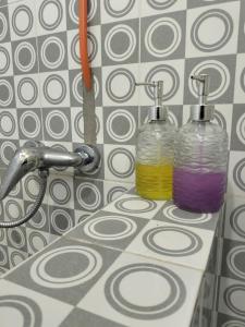 two glass bottles sitting on a counter in a bathroom at Gio's Place in Labuan Bajo