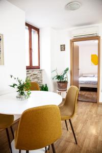 comedor con mesa blanca y sillas amarillas en Rosa di Pirano, en Piran