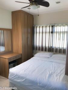 een slaapkamer met een groot wit bed en een bureau bij 2 Bedroom Condo @ Midpoint Residences w/ City View in Mandaue-stad