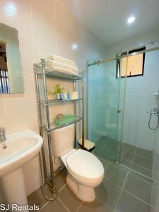 a bathroom with a toilet and a glass shower at 2 Bedroom Condo @ Midpoint Residences w/ City View in Mandaue City