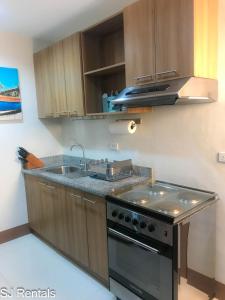 a kitchen with a stove and a sink at 2 Bedroom Condo @ Midpoint Residences w/ City View in Mandaue City