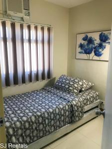 sypialnia z łóżkiem i oknem w obiekcie 2 Bedroom Condo @ Midpoint Residences w/ City View w mieście Mandaue City