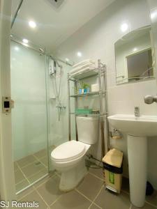 a bathroom with a toilet and a shower and a sink at 2 Bedroom Condo @ Midpoint Residences w/ City View in Mandaue City