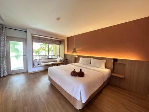 Un dormitorio con una cama grande con dos zapatos. en Baan Karon Resort en Karon Beach