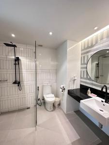 La salle de bains est pourvue de toilettes, d'un lavabo et d'une douche. dans l'établissement Baan Karon Resort, à Karon Beach