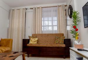 a living room with a couch and a window at Zuri Cosy Apartment in Busia