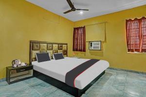 een slaapkamer met een groot bed en gele muren bij Collection O Hotel Ns Sheetal in Raipur