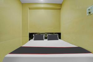 een slaapkamer met een bed met 2 kussens erop bij Collection O Hotel Ns Sheetal in Raipur
