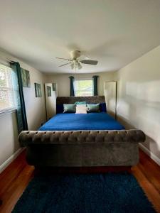 Schlafzimmer mit einem großen Bett mit blauer Decke in der Unterkunft Cozy Cul de Sac Maryland Home near FedEx Field in District Heights