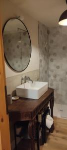 a bathroom with a white sink and a mirror at Bilocale a due passi dal mare immerso nel verde in Castiglioncello