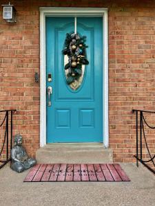 eine blaue Tür auf einem Backsteingebäude mit einer Statue in der Unterkunft Cozy Cul de Sac Maryland Home near FedEx Field in District Heights