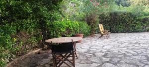einen Tisch und Stühle auf einer Steinterrasse in der Unterkunft Bilocale a due passi dal mare immerso nel verde in Castiglioncello